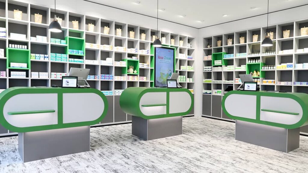 Äskulap Apotheke Riesa-Weida Kassenbereich mit Regalen im Hintergrund in weiß-grüner Optik