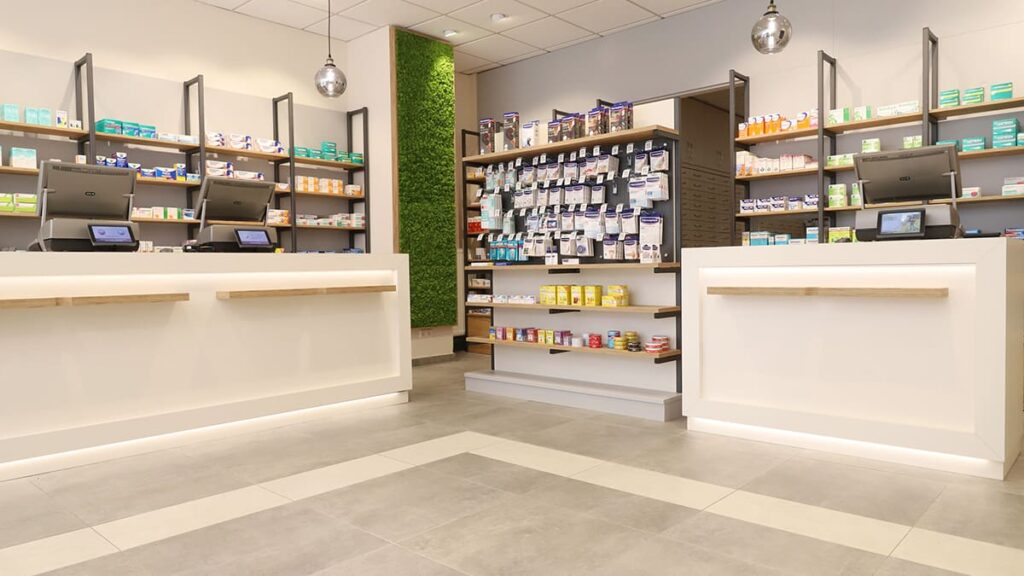 Markt Apotheke Bernburg Blick auf Kassenbereich mit indirekter Beleuchtung vor den Kassen und offenen Regalen hinter den Kassen